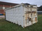 a white container sitting on the grass in front of a building
