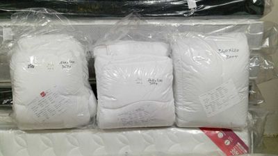 three bags of white pillows on top of each other