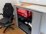 un bureau avec un ordinateur et une chaise devant
