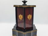 une petite horloge noire et dorée posée sur une surface blanche