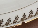 a close up of a white plate with a gold border
