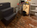 a shopping cart in the corner of a room next to a stove