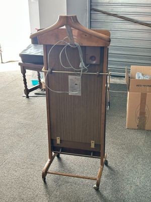 a wooden cabinet with a coat hanger on top of it