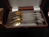 five spoons in a box on a table