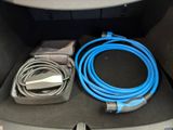a blue cable connected to a charger in the trunk of a car