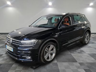 un SUV Volkswagen noir garé dans un garage au sol carrelé