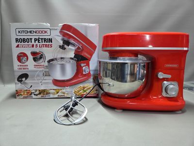 un mixeur rouge et une boîte de nourriture posés sur une table