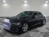 L'Audi noire est garée dans une grande pièce au sol carrelé.