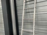 two ladders leaning against the wall next to each other