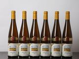 six bouteilles de vin sont alignées sur une table en bois
