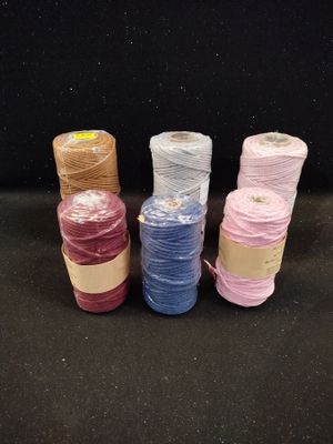 four spools of different colors of thread on a black surface