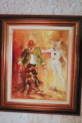 framed painting of a clown and a cat on a wall
