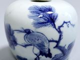 a blue and white vase with a bird on it