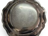 a silver plate on a white surface with a silver background