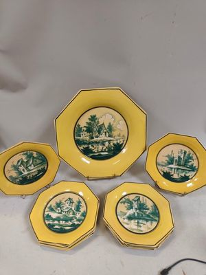 six assiettes jaunes et vertes sur lesquelles est représenté un village