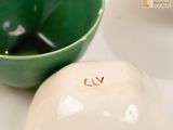 a white bowl and a green bowl sitting on a table