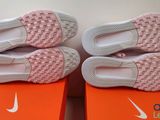 two pairs of pink and white shoes are on top of a box
