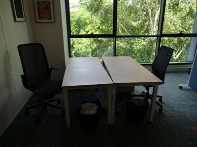 un bureau avec deux chaises devant une grande fenêtre
