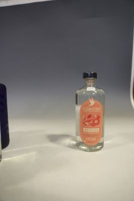a bottle of alcohol sitting on a counter next to a bottle of liquor