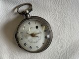 une montre de poche en argent avec des chiffres romains