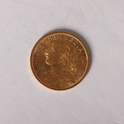 a close up of a gold coin on a white surface