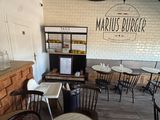 tables and chairs in a restaurant with a brick wall behind them