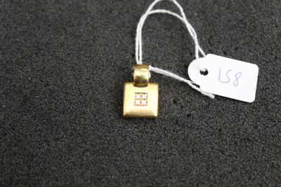 a small gold necklace with a small house on it