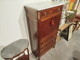 a cabinet with a marble top next to a small table