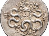 a close up of a silver coin with a snake on it