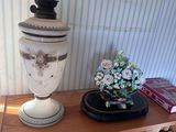 un vase blanc posé sur une étagère en bois à côté d'une bibliothèque