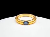 a close up of a gold ring with a blue stone in it