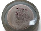 a close up of a dirty glass jar with writing on it