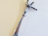 a silver spoon with a bird on it sitting on a piece of paper