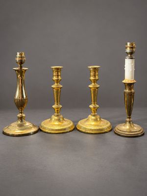un ensemble de quatre bougeoirs en laiton