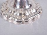 a silver candle holder on a white table cloth