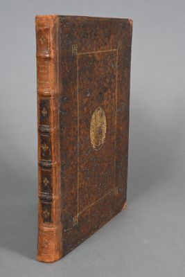 un vieux livre posé sur une table à côté d'un fond gris