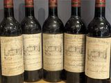 six bottles of wine are lined up on a wooden shelf