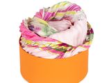 une boîte à chapeaux orange contenant un foulard, sur fond blanc