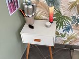 une petite table sur laquelle se trouve une bougie, dans un coin de la pièce
