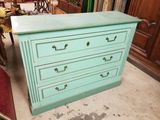 une commode bleue à quatre tiroirs dans une pièce