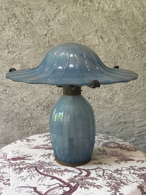 a blue lamp that is on a table with a red and white table cloth
