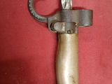 a picture of a very old looking knife on a red cloth
