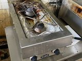 une cuisinière sale dans une cuisine sale, avec des casseroles et des poêles posées dessus
