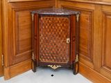 une armoire d'angle avec un plan de travail en marbre, placée dans un coin