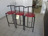 three red stools sitting on the floor in a room