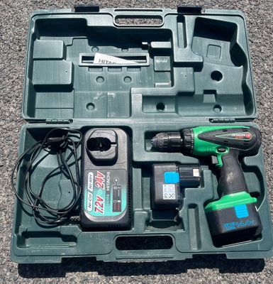 a green tool box with tools in it on the ground