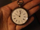 a person holding a pocket watch in their hand