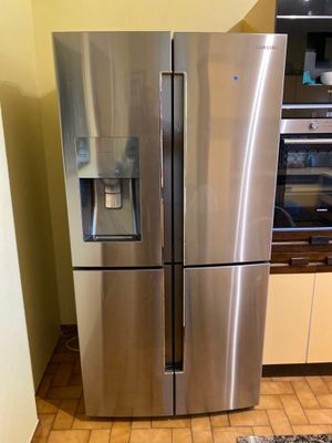 a stainless steel refrigerator in a kitchen with tile flooring