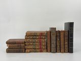 several old books stacked on top of each other on a white surface