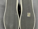 a close up of a pair of black and white shoes on a gray surface